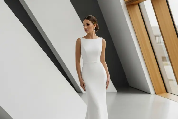 A minimalist sheath wedding dress hugging the natural curves of a bride.