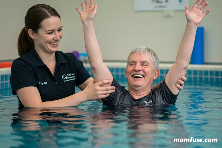 A joyful moment in a hydrotherapy pool where a person with disabilities is engaging in a gentle water exercise.