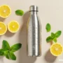 A refreshing flat-lay of a water bottle, lemon slices, mint leaves in table.