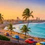 Tropical view of Cuba with colorful colonial towns, turquoise coastline, classic vintage cars, palm trees.