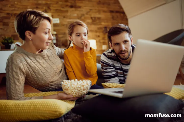 A family watching a home movie together in a living room