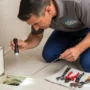 A realistic, high-resolution photo of a professional plumber inspecting a home drain.