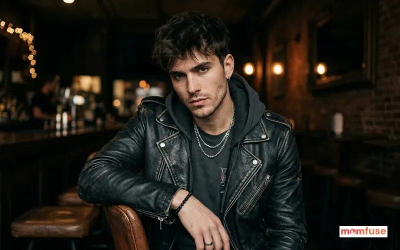 young man with intense confident expression, modern edgy outfit, dark background.