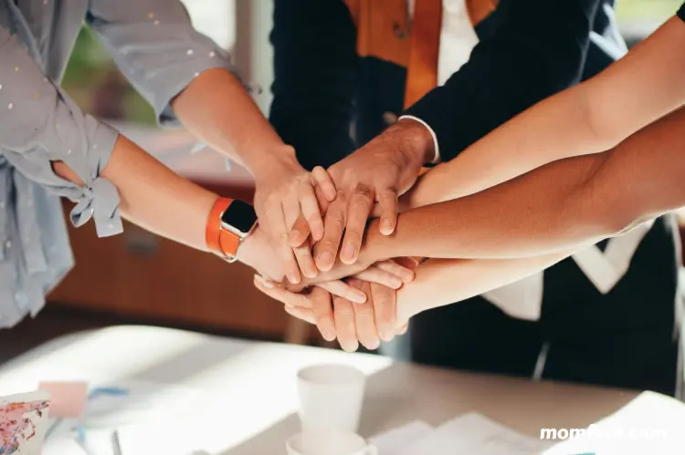 Team hands stacked in unity.