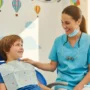 A warm, friendly pediatric dental clinic scene with a smiling child sitting in a dental chair.