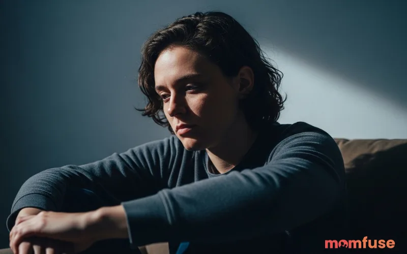 Thoughtful person sitting alone with reflective expression, moody lighting, emotional human portrait