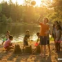 A joyful summer camp scene in warm golden sunlight.