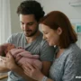 An emotional moment of two intended parents holding a newborn baby in a hospital room.