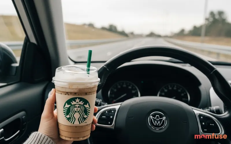 “person holding Starbucks coffee in car, cozy morning drive-thru vibe, soft sunlight, lifestyle aesthetic”