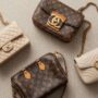 A minimalist flat lay of three luxury pre-owned handbags (Chanel, Louis Vuitton, Gucci).