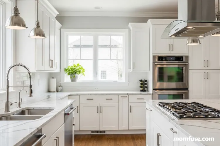 Beautiful modern kitchen with white shaker cabinets, marble countertops, stainless steel.